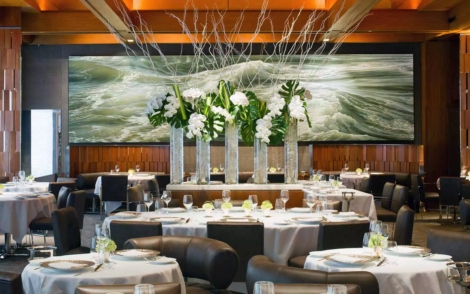 Elegant Dining Area with Tables Set in Linen and Glassware
